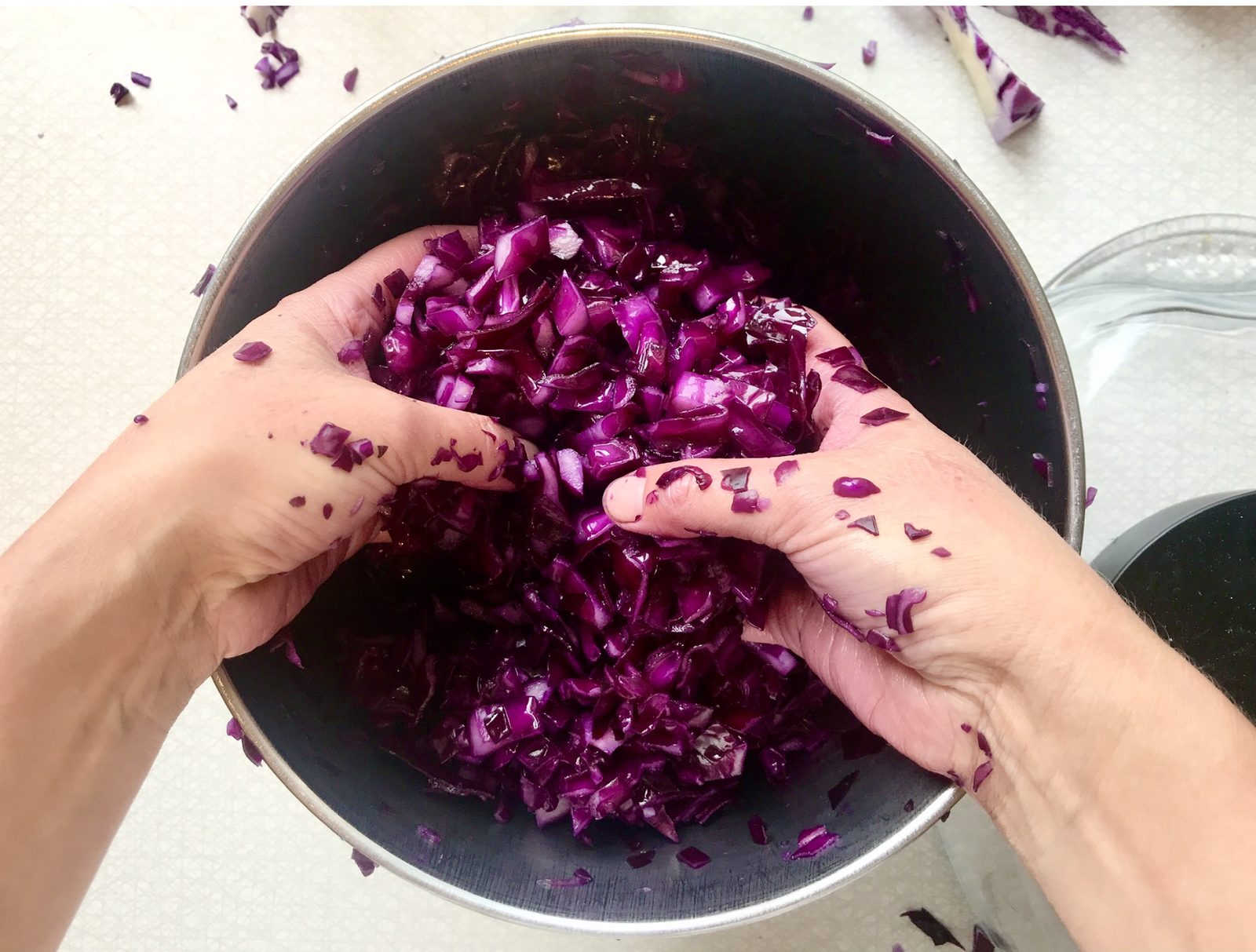Hands preparing fermented red cabbage