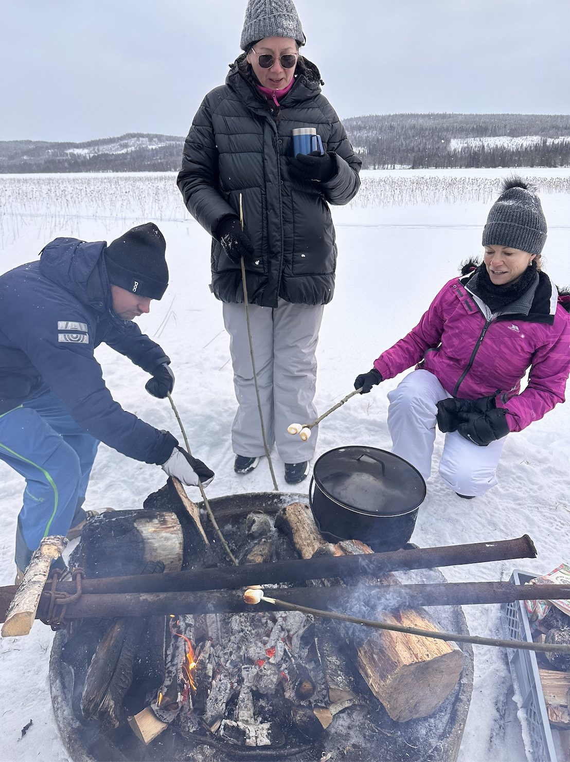 Friends around an open fire on the ice
