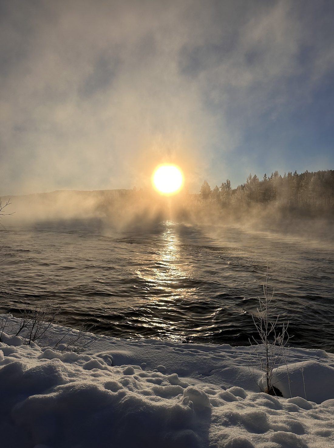 Sun rising through mist over a frozen Swedish river